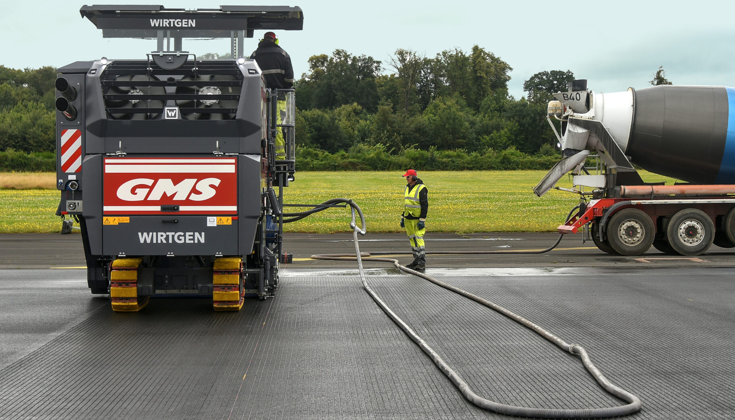 Mit Wasserwagen wurden die beiden Grooving-Fräsen mit Kühlwasser für die Schneidwalze versorgt. Statt des Ladeband-Systems ist im vorderen Teil eine Absauganlage für den Frässchlamm montiert. Der Frässchlamm wurde damit in eigens dafür bereitstehende Betonfahrmischer gepumpt.
